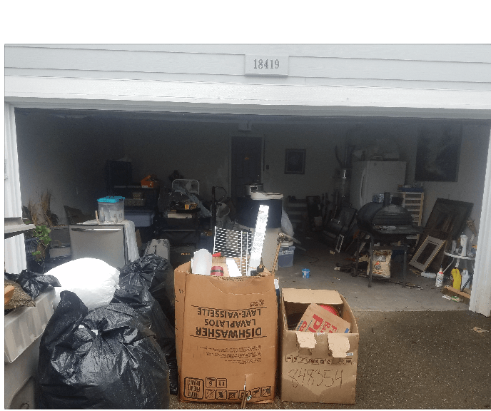 Garage filled with assorted items, boxes, and garbage bags.